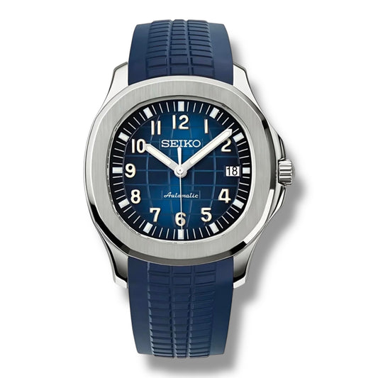 Montre Seiko automatique avec cadran bleu texturé et index luminescents blancs. Boîtier en acier inoxydable brossé, bracelet en caoutchouc bleu résistant et fonction date discrète à 3 heures. Style sophistiqué et sportif idéal pour les aventures quotidiennes