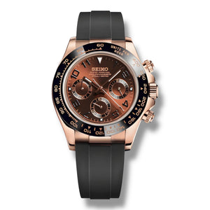 Montre Skona Rosegold avec boîtier en or rose, cadran brun cuivré et sous-cadrans assortis. Lunette tachymétrique noire et bracelet en caoutchouc noir pour un style luxueux et moderne